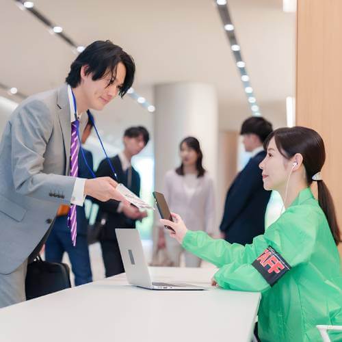 Staff Checking Visitor Attendance Through A Website Created By A Website Designer For Event Management Company Singapore